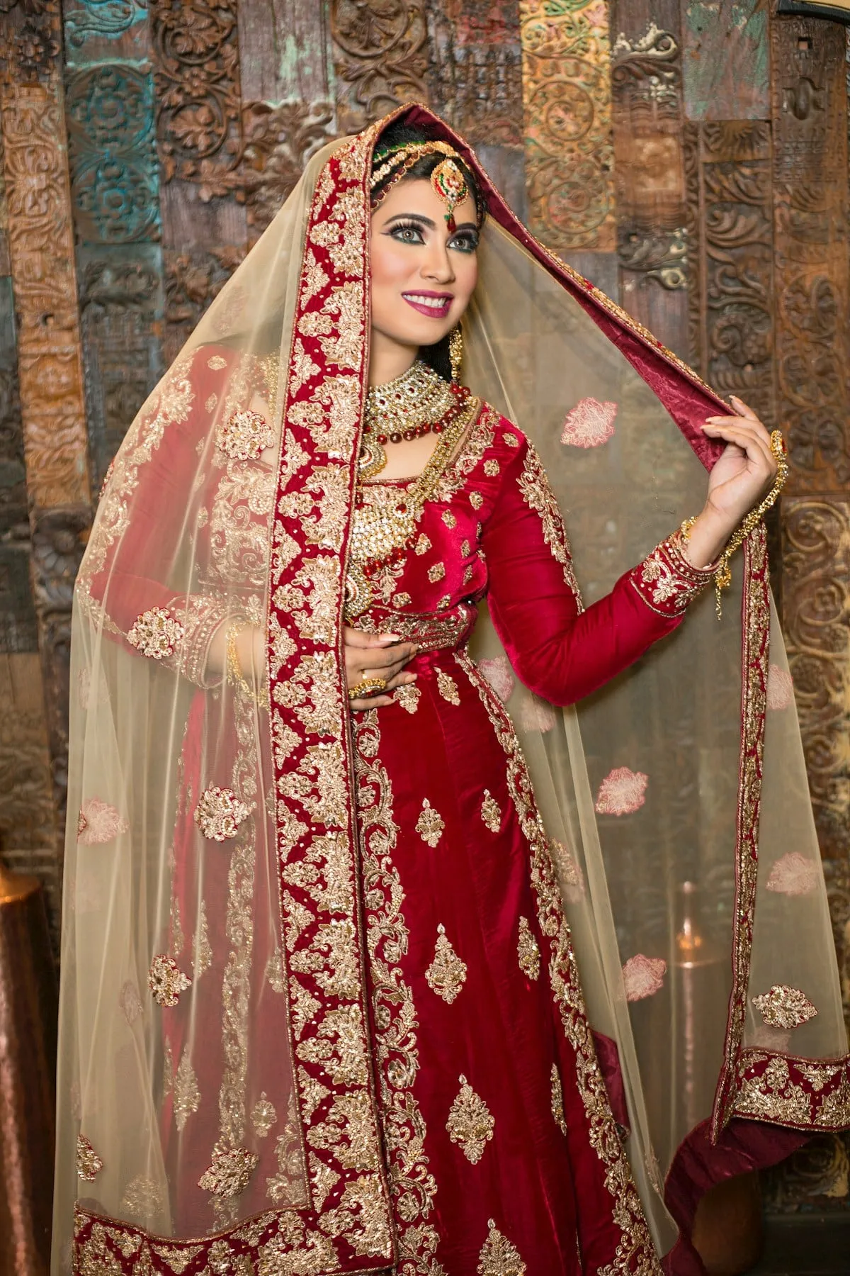 Bride in a red reception outfit with a gold-edged dupatta