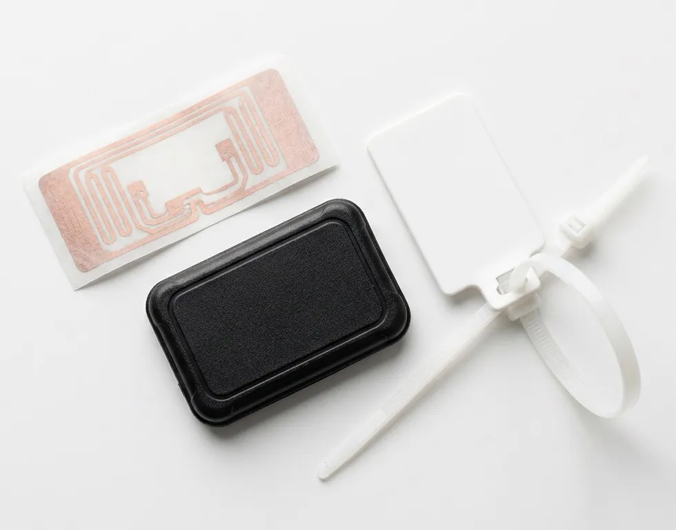 A paper RFID inlay, a black on-metal tag and a white cable-tie tag